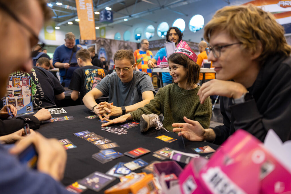 Zwei Personen spielen an einem Tisch auf der SPIEL Essen