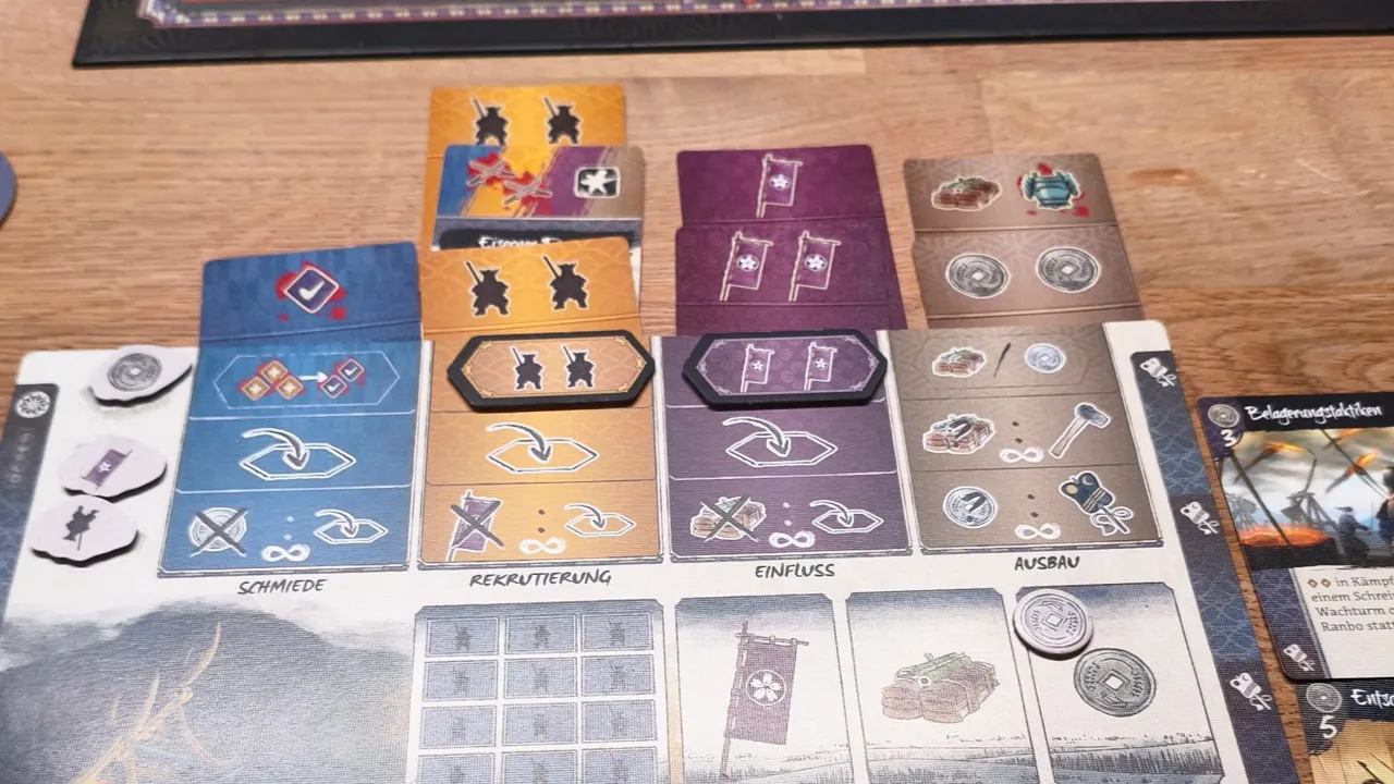 Spielertableau mit mehreren farbigen Spalten aus übereinanderliegenden Befehlskarten
