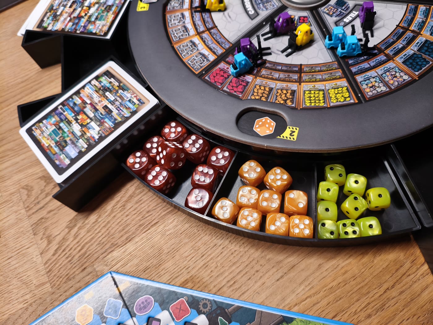 The Game Makers: Ressourcenschubladen mit roten, orangen und grünen Würfeln